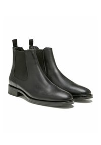 Bottines Chelsea en cuir noir avec panneaux élastiques sur les côtés, surface lisse, bout arrondi et petit talon empilé.