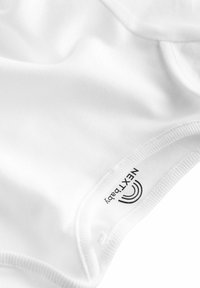 Bodysuit pour bébé en coton blanc avec une texture douce, un col rond et des manches courtes. Porte l'étiquette « NEXT Baby » à l'intérieur.