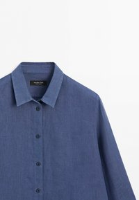 Blue long-sleeve button-up shirt with a collar, made from a textured fabric, displayed against a white background.