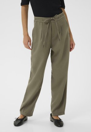 Olive green high-waisted trousers with wide legs, pleated front, and a drawstring waistband, paired with black flat shoes.