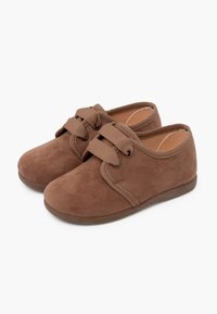 Pantofi din suede maro cu vârful rotunjit, având două braturi din material peste glezna piciorului și o talpă din cauciuc flexibilă. Căptușeală interioară moale.