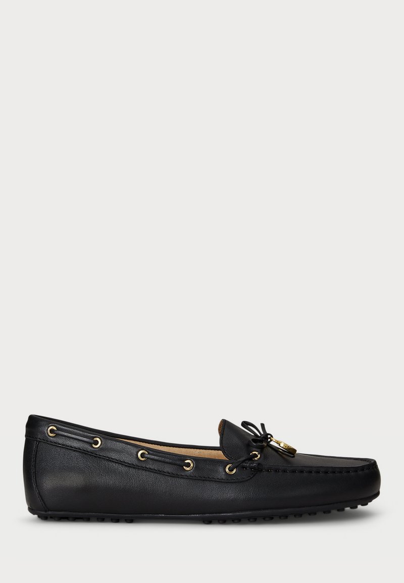 Μαύρο δερμάτινο loafers με χρυσές θηλιές, δέσιμο σε φιόγκο και σόλα με λάστιχα, εμφανίζεται από το πλάι σε λευκό φόντο.