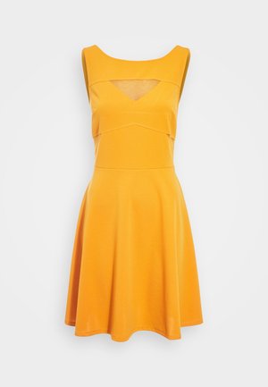 Robe jaune sans manches avec un corsage ajusté, une découpe en V sous l'encolure carrée, et une jupe évasée.