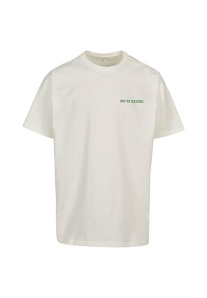 Kerman cotton t-paita lyhyillä hihoilla ja pyöreällä pääntiellä, jossa on etupuolella vihreä teksti "9N1M SENSE." Sujuva rakenne, normaali mitoitus.