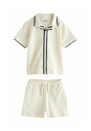 Cream short-sleeve button-up shirt with black trim and matching drawstring shorts with side pockets, laid flat on a white background.