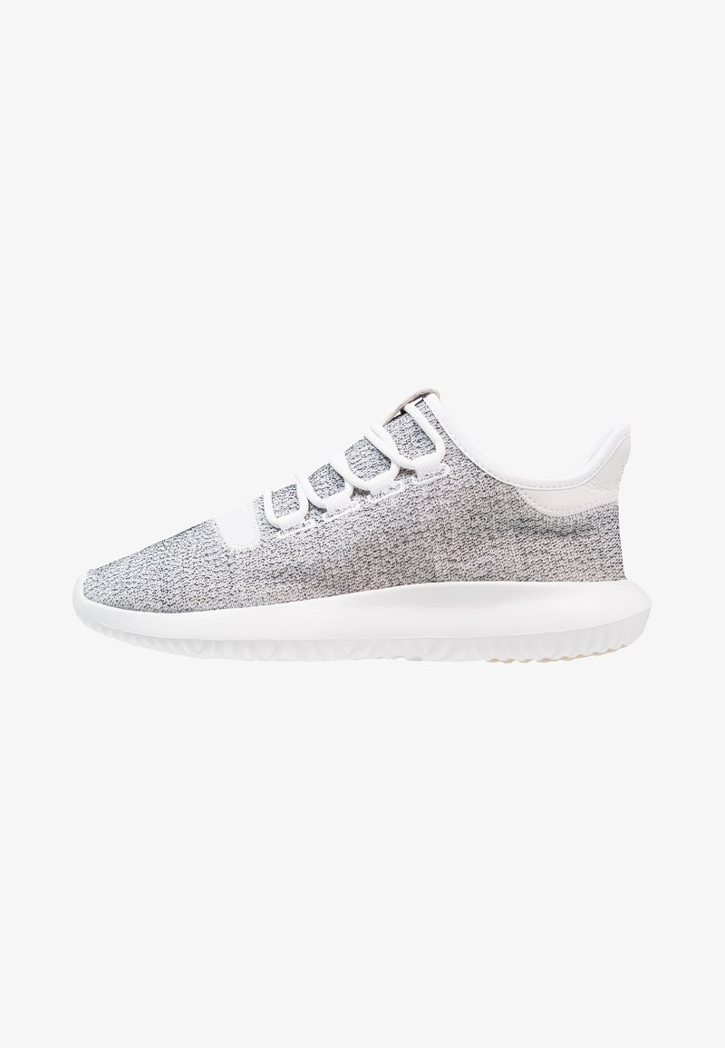 Baskets de sport en tricot gris avec des accents blancs, présentant un profil bas, une tige texturée, un design à lacets et une semelle en caoutchouc flexible.
