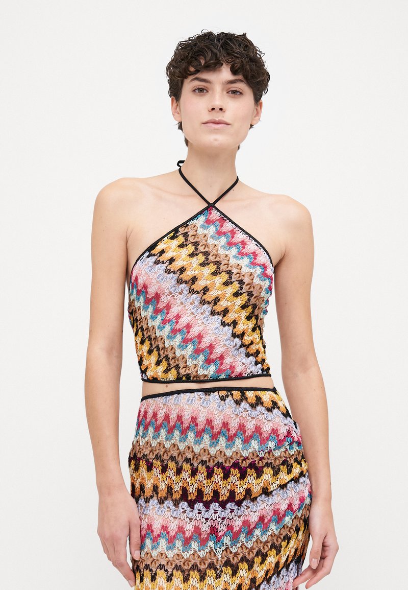 Färgglad virkad halterneck-topp med zigzag-mönster i rosa, gult, blått och svart. Den har en åtsittande, kort design med tunna band.