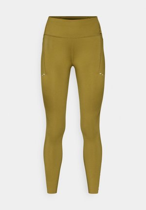 Leggings verde oliva con cintura alta, confeccionados con material elástico, que cuentan con un pequeño bolsillo lateral y detalles sutiles de costuras.