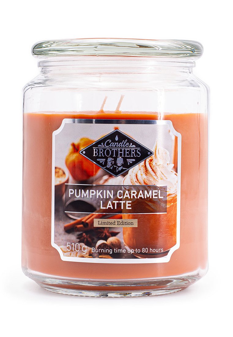 Bougie en verre avec de la cire orange, affichant une étiquette noire et argentée portant l'inscription "Pumpkin Caramel Latte" avec des images de citrouilles et d'épices.
