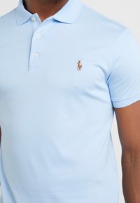 Světle modrá polokošile z bavlny s dvouknopovým límečkem, krátkými rukávy a malým vyšitým logem koně na hrudi.