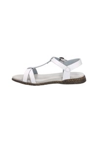 White leather sandal with T-strap design, adjustable ankle strap, flat cork sole, and soft textured footbed. Minimalist and open design.