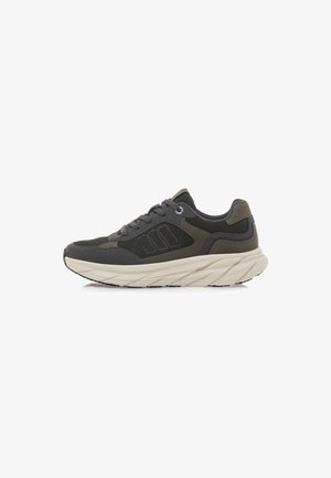 Sneaker grigia con tessuto testurizzato e sovrapposizioni lisce. Presenta una suola spessa e ondulata di colore bianco sporco e lacci per la chiusura.
