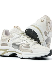 Weiße und beige Mesh-Sneaker mit metallischen silbernen Akzenten, einer gepolsterten Sohle und einer strukturierten Oberfläche. Verfügt über Schnürung und ein Logodetail an der Ferse.