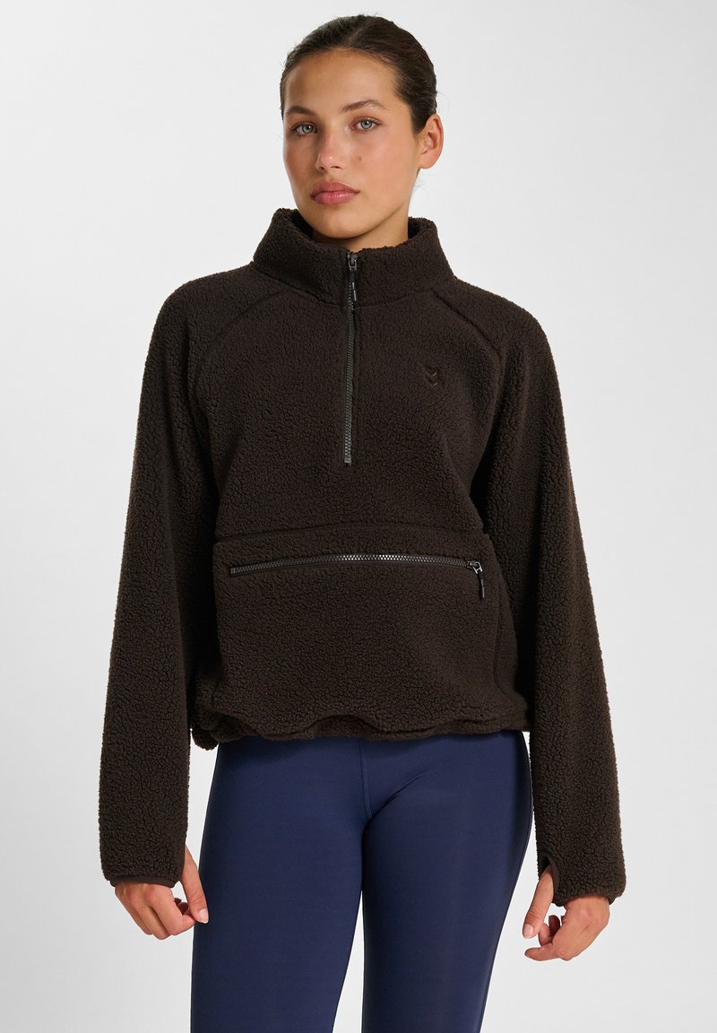 Brun fleece halvdraget pullover med ficka med dragkedja framtill, långa ärmar och scalloped nederkant. Texturerad yta ger värme och komfort.