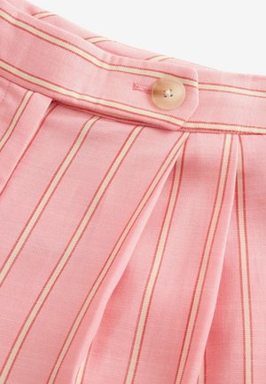 Helles rosa Fabric mit vertikalen roten Streifen, entspannten Falten und einer abgerundeten Knopfverschlusseinstellung am Bund. Glatte Textur.
