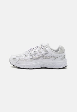 Chaussure de course Nike blanche avec panneaux en mesh, fermeture à lacets, semelle coussinée et semelle extérieure noire, présentée en profil droit sur un fond uni.