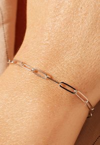 Zilveren schakelenarmband met een reeks van langwerpige paperclip-vormige schakels, die een combinatie van glanzende en matte afwerkingen toont.