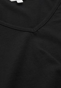 Sort bomulds V-hals T-shirt med en glat tekstur, forstærkende syninger ved halsudskæringen og et minimalistisk design.