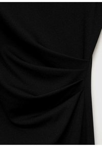 Svart klädtyg med mjuk drapering, med en rynkad design på ena sidan. Slät textur, minimala detaljer och en elegant silhuett.