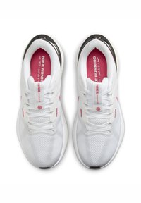 Zapatillas deportivas blancas con parte superior de malla, acentos en rosa, cordones redondos y suela acolchada. Presentan un contrafuerte negro en el talón y una marca en la lengüeta.