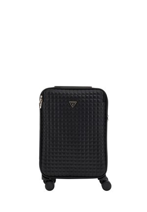 Valigia rigida nera trapuntata con quattro ruote, una maniglia superiore e una targhetta triangolare con il logo Guess al centro davanti.