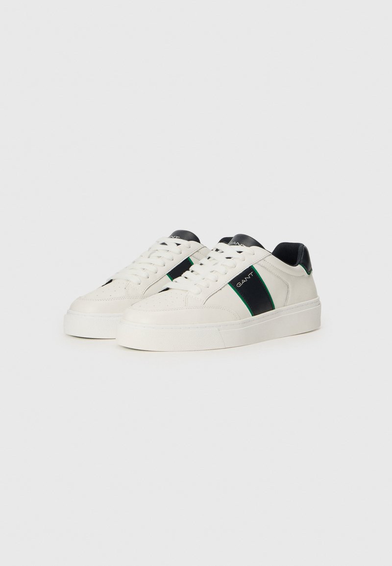 Weiße Sneaker mit schwarzen Fersen- und Seitenakzenten, versehen mit grünen Streifen. Hergestellt aus Leder mit strukturiertem Finish und flacher Gummisohle.