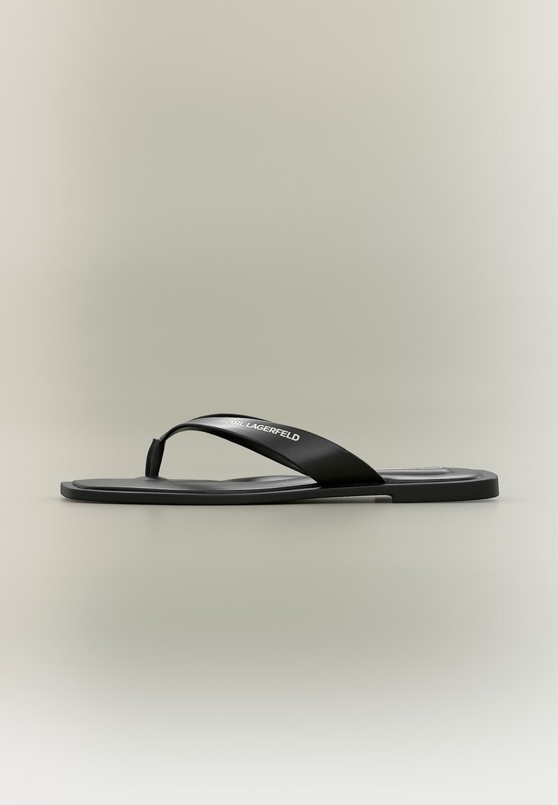 Μαύρο σανδάλι από καουτσούκ με επίπεδη σόλα και φαρδύ λουρί με την επωνυμία "Karl Lagerfeld" σε ουδέτερο φόντο.