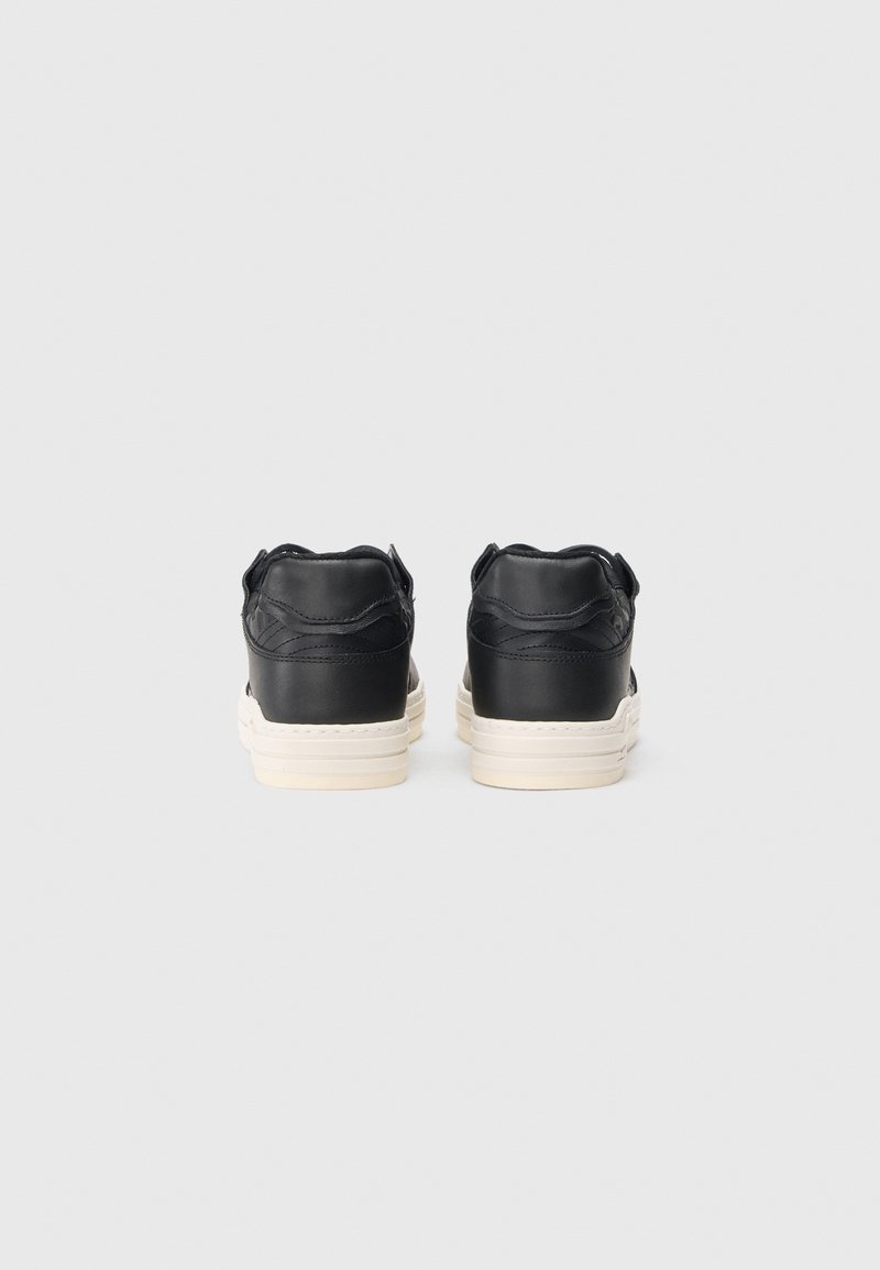 Black leather sneakers with a smooth texture, white midsole, and rounded heel; features a stitched design and soft rear collar.