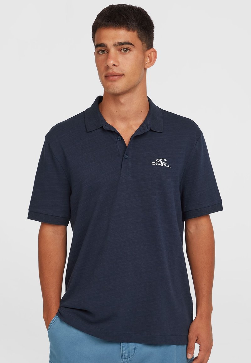 Polo shirt bleu marine à manches courtes et col boutonné. Présente un logo brodé en blanc sur la poitrine. Tissu doux et texturé.