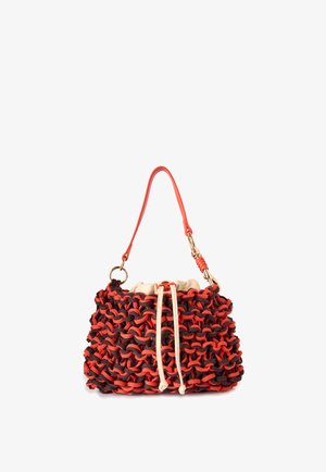 Petit sac à main avec extérieur tissé épais rouge et noir, fermeture à cordon en tissu beige et une bandoulière courte rouge avec ferrures dorées.