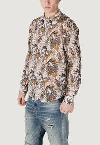 Camicia a maniche lunghe con uno sfondo bianco e una stampa colorata di foglie tropicali e scimmie, realizzata in un tessuto leggero con colletto classico.