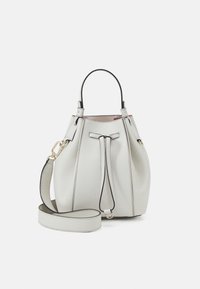 Lichtgrijze leren bucketbag met een trekkoordsluiting, een bovenhandgreep en een afneembare schouderriem; voorzien van zwarte accenten en een gladde textuur.