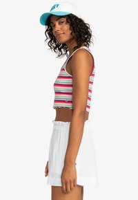 Gestreepte, cropped tanktop in roze, groen en blauw, met een gegolfde zoom. Gecombineerd met witte, gestructureerde shorts met een gerimpelde tailleband.