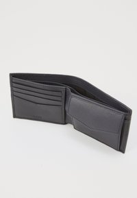 Portafoglio in pelle blu navy con più slot per carte, una sezione per banconote e una texture liscia. L'interno presenta un rivestimento morbido a contrasto.