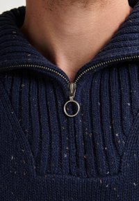 Marine gebreide pullover met ribbeltextuur, halve rits en een zilverkleurige metalen rits. Bevat meerkleurige spikkels door de stof.