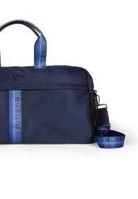 Navy modrý nylonový sáček s dvojitými horními uchy, nastavitelným ramenním popruhem a texturovanou tkaninou. Obsahuje svislé pruhy s akcenty loga.