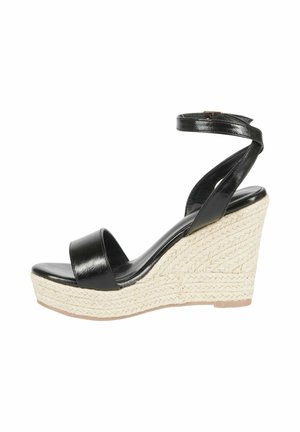 Sandalo con zeppa in pelle nera, dotato di una larga fascia frontale e una fascia alla caviglia, con un tacco in espadrillas intrecciate testurizzate.