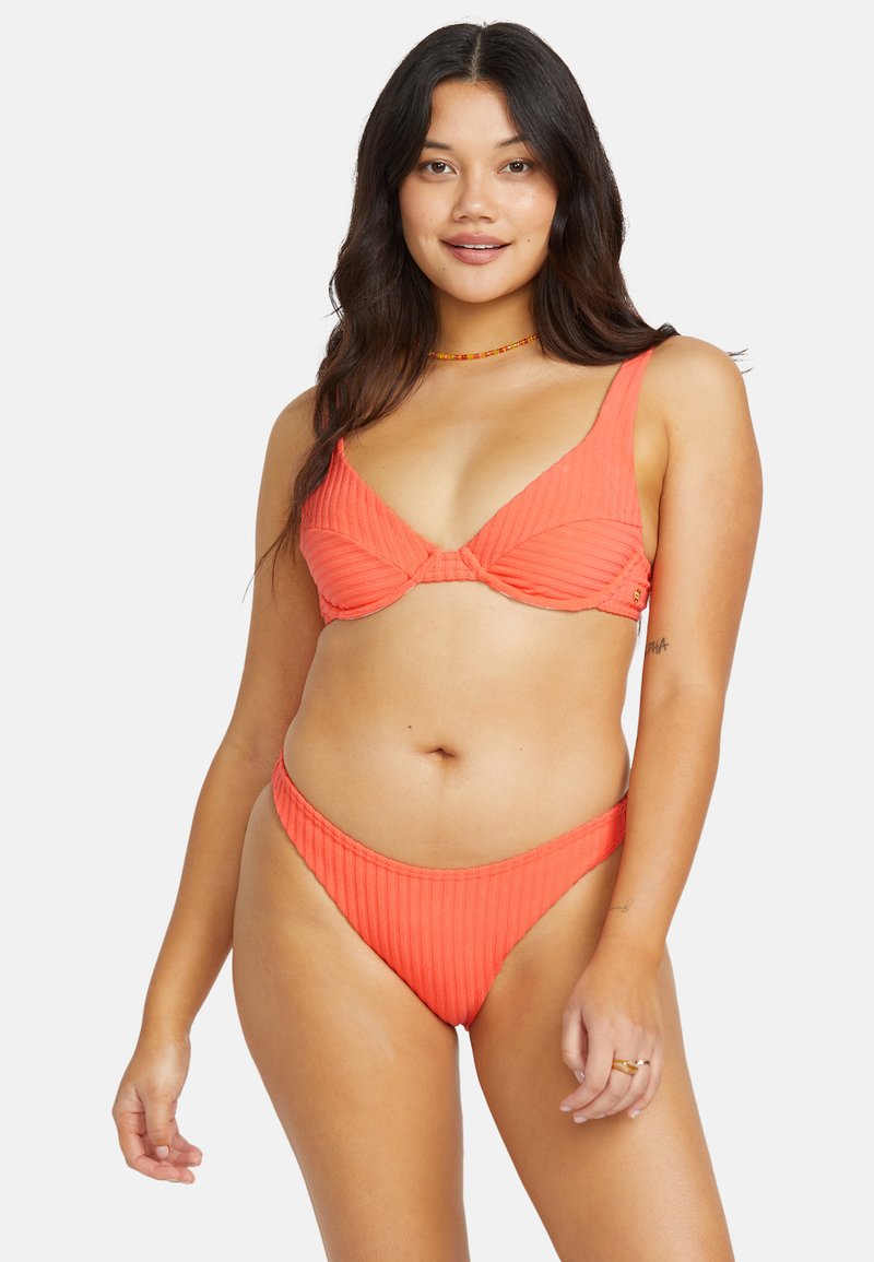 Korallenfarbenes Rippbikini mit breiten Trägern, Unterbruststütze im Oberteil und hochgeschnittenem Höschen, das eine glatte Textur und nahtloses Design präsentiert.