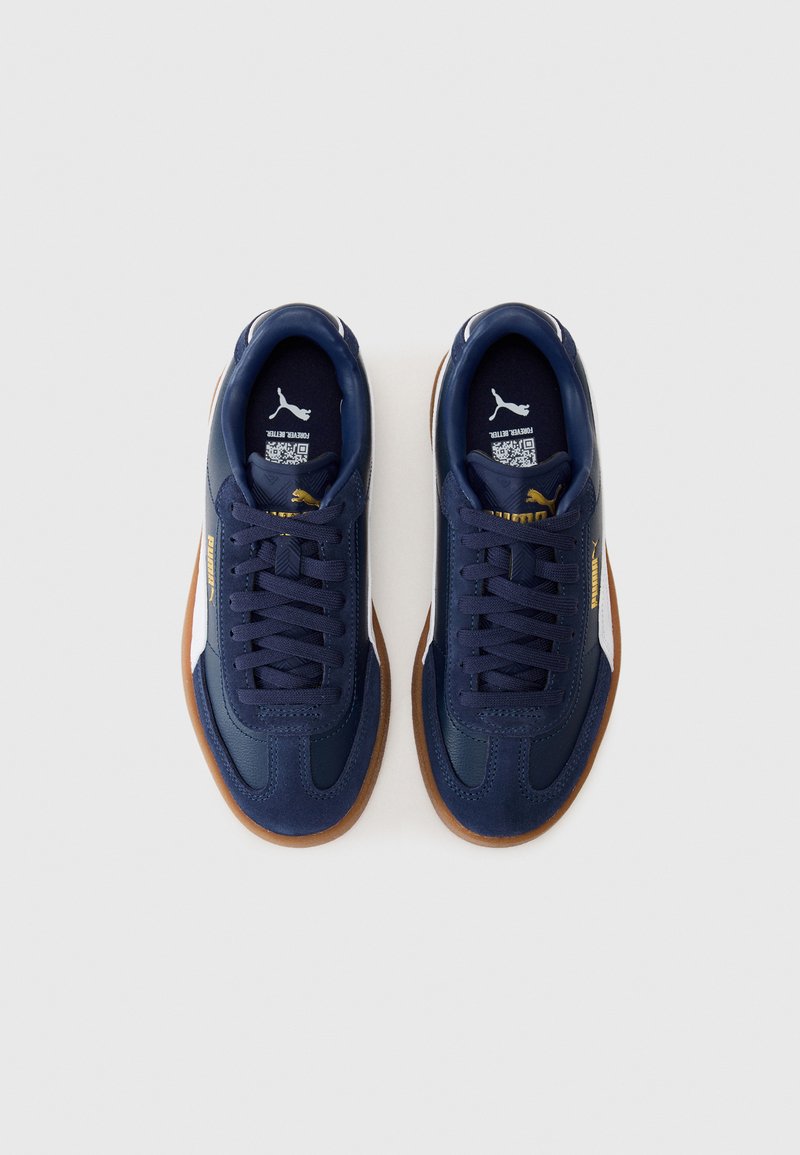 Zapatillas azul marino hechas de cuero y ante con suela de goma, con cordones redondos y un acento blanco en el talón.