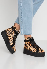 Leopardi kuosi korkeapohjaiset tennarit mustilla yksityiskohdilla, joissa on pehmeä tekstuuri, rohkea malli ja muodikkaat paksut pohjat.