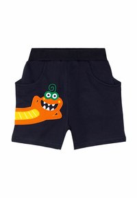 Marineblå bomulds shorts med et orange monstermotiv med grønne detaljer, to sidelommer og en elastisk talje for komfort.