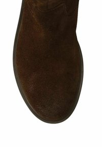 Bottine en suédine marron avec un bout rond et une semelle en caoutchouc lisse. La tige présente une texture douce sans motifs ni quincaillerie visibles.