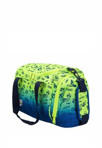 Sac de sport vert et bleu avec un imprimé sur le thème du football, des zippers et des poignées bleu marine. Il présente une forme structurée et une texture lisse.