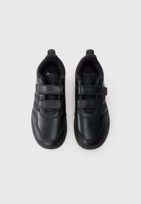 Ζευγάρι μαύρα δερμάτινα αθλητικά παπούτσια με διπλές λουράκια βέλκρο, γλώσσα από δίχτυ και μαλακό γιακά, σε θέα από πάνω σε λευκό φόντο.