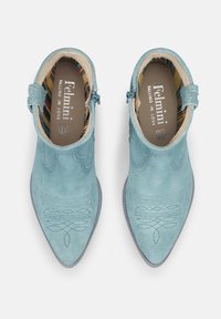 Stivali alla caviglia in suede blu cielo con punte appuntite, dettagli di cucitura intricati e una fascia con fibbia; fodera interna a righe multicolori.