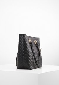 Schwarze, gesteppten Handtasche mit zwei Obergriffen, ausgestattet mit goldfarbenen Beschlägen und einer strukturierten Form. Glatte Textur mit Diamantmuster-Detaillierung.