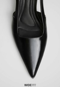 Chaussure femme noire à bout pointu, largeur large, finition brillante et semelle intérieure rembourrée vue de dessus.