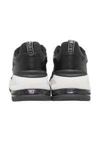 Baskets Buffalo noires et blanches vues de dos, avec des semelles épaisses embossées du nom de la marque et des languettes de traction aux talons.