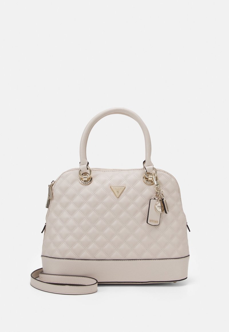 Quilted beige handbag with gold hardware, top handles, detachable shoulder strap, and logo detail. Smooth texture with structured shape.