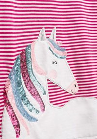 Valkoinen puuvillainen t-paita, jossa on vaaleanpunaisia ja valkoisia raitoja. Siinä on paljeteilla koristeltu yksisarvinen pastellivärisine harjaksineen ja kasvonpiirteineen.